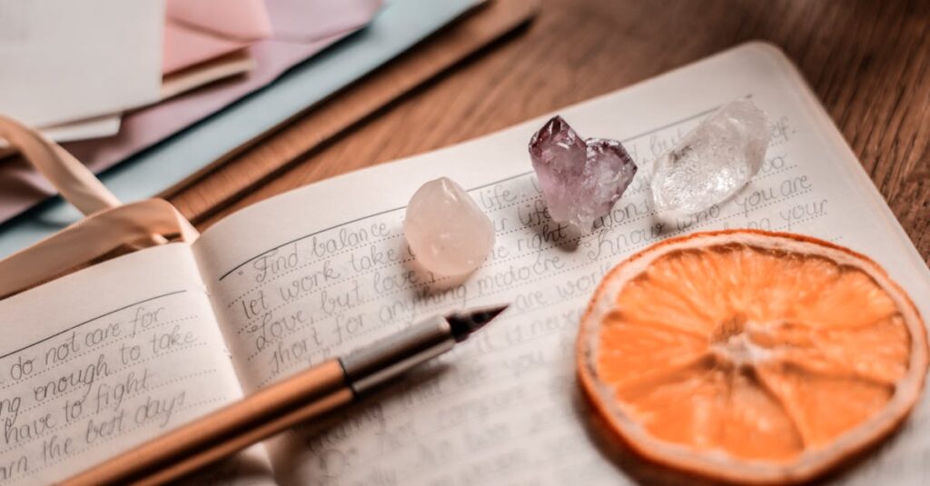 Aesthetic journal scene featuring crystals, a pen, and a dried orange slice on a wooden table.